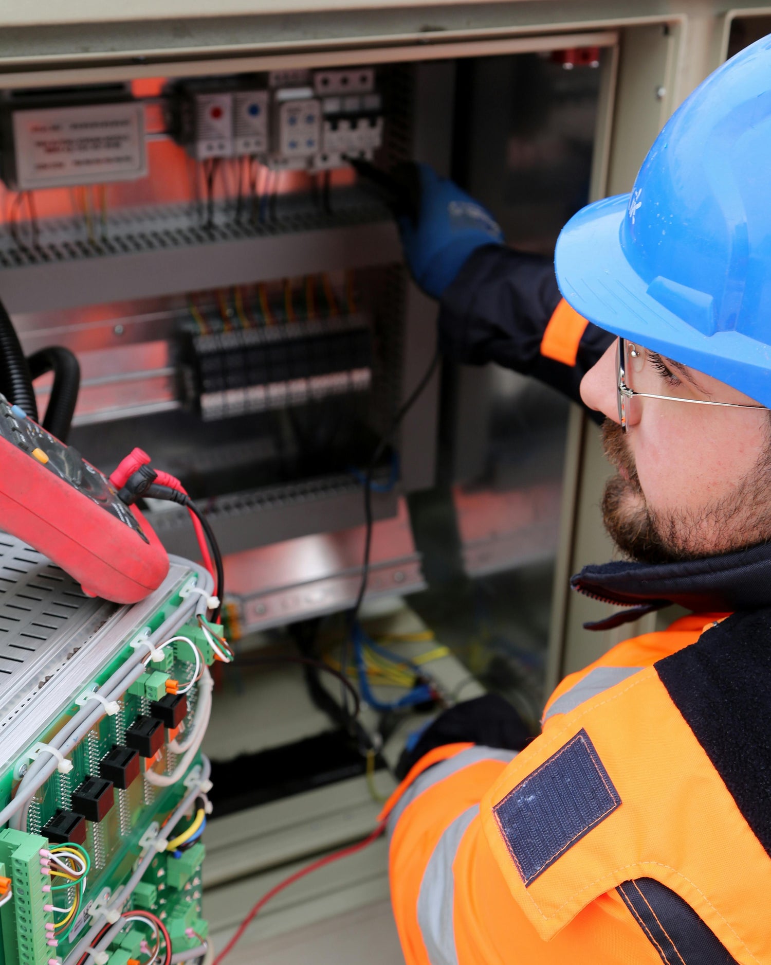 Person in safety gear working on electrical equipment